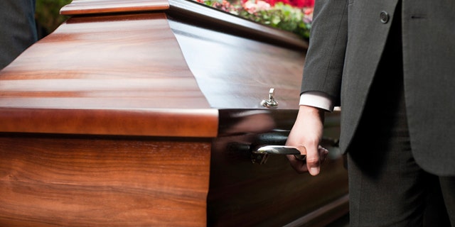coffin bearer carrying casket at funeral