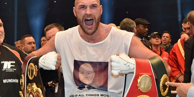 In this Nov. 29, 2015 file photo, Britain's new world champion Tyson Fury, celebrates with the WBA, IBF, WBO and IBO belts after winning the world heavyweight title fight against Ukraine's Wladimir Klitschko in Duesseldorf, western Germany.