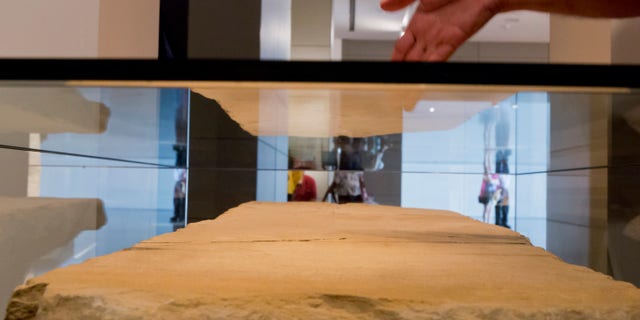 A visitor looking at the stone tablet called the Gabriel Revelation Stone on display at the Israel Museum. The stone is a centerpiece of an exhibition called, 'I am Gabriel,' which is written in Hebrew on the stone, with some 80 lines of writing. The tablet dates from the Second Temple era of the Jewish revolt after the death of Herod, and was discovered in 2007 near the Dead Sea scroll caves at the Dead Sea. The tablet is exhibited with a number of rare manuscripts that trace the figure of the Angel Gabriel across the early years of rabbinic Judaism, Christianity, and Islam. (EPA/JIM HOLLANDER)