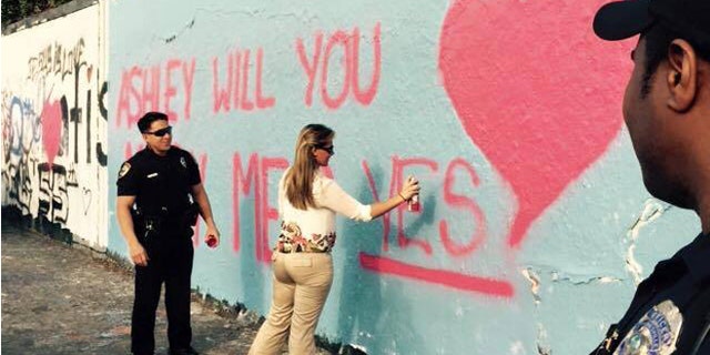Officer Christian Hickey proposes to girlfriend Ashley Alderman at Gainesville, Fla., 34th Street graffiti wall. (Gainesville Police Department)