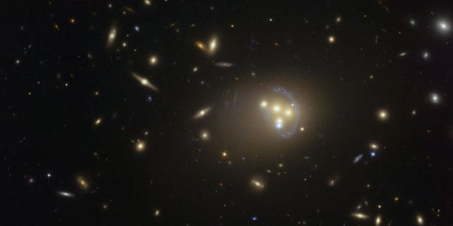A Hubble Space Telescope image of galaxy cluster Abell 3827, where dark matter may have been observed interacting with itself during a galaxy collision.