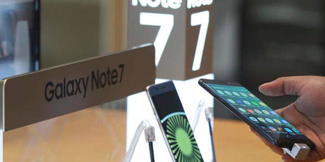 A visitor tries out a Samsung Galaxy Note 7 smartphone at a shop in Seoul, South Korea, Monday, Oct. 10, 2016.