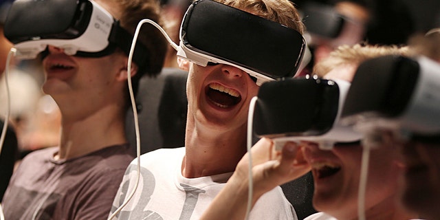 Persons with virtual reality headsets have fun at the gamescom fair in Cologne, Germany, Wednesday Aug. 23, 2017.