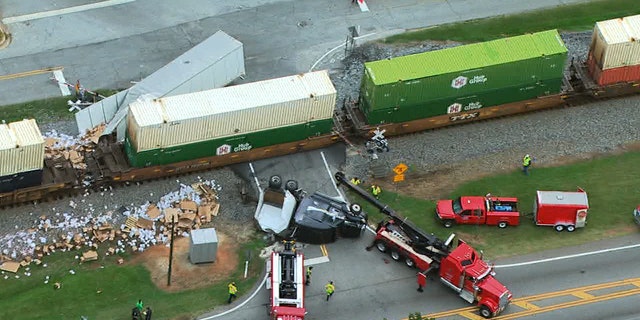 Emergency personnel respond to the site of a collision involving a train and a semi-truck in Henry County, Ga. Thursday.