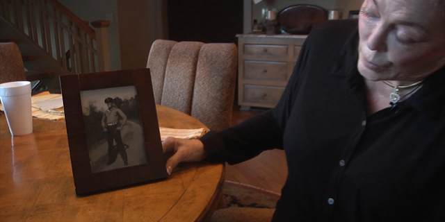 Pam Cunningham Averso displays a photo of her father in his Marine uniform.