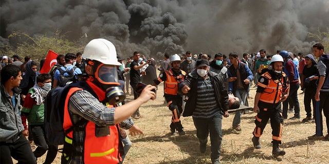 April 6, 2018: Palestinian protesters and civil defense evacuate a wounded youth during clashes with Israeli troops along Gaza's border with Israel.