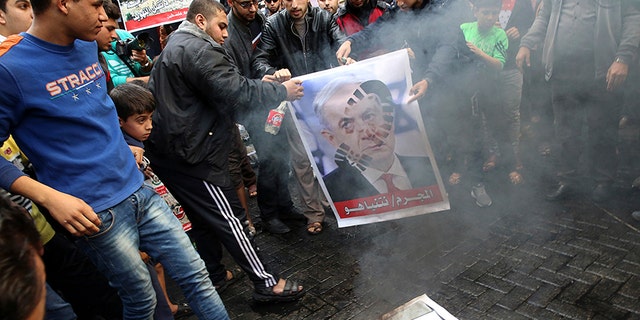 Hamas supporters burn a picture of Israeli Prime Minister Benjamin Netanyahu during a protest in the Gaza Strip.