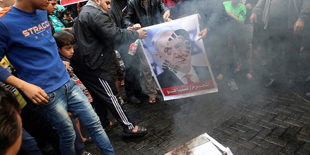 Hamas supporters burn a picture of Israeli Prime Minister Benjamin Netanyahu during a protest in the Gaza Strip.