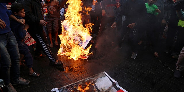 Hamas supporters burn a picture of Israeli Prime Minister Benjamin Netanyahu during protest against President Trump.