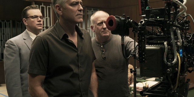 Matt Damon, left, poses next to George Clooney, center, on the set of "Suburbicon."