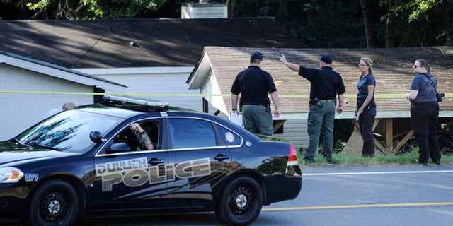 Law enforcement investigate the scene of a shooting at a home in Suwanee, Ga., Wednesday, July 22, 2015. Officers initially found three people dead and two wounded, including the suspect, Forsyth County sheriff's officials said. The wounded were taken to hospitals, where one died, Deputy Robin Regan said. But it wasn't clear whether that was the suspect or the other person. (AP Photo/John Amis)