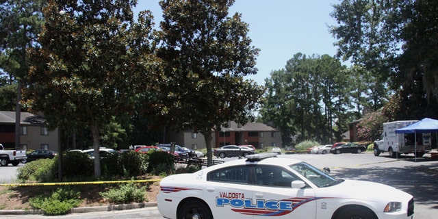 A police vehicle parks near the scene of an officer involved shooting, Friday, July 8, 2016, in Valdosta, Ga. A man who called 911 to report a car break-in Friday ambushed a south Georgia police officer dispatched to the scene, sparking a shootout in which both the officer and suspect were wounded, authorities said. Both are expected to survive.(Gabe Burns/The Daily Times via AP) MANDATORY CREDIT