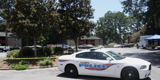 A police vehicle parks near the scene of an officer involved shooting, Friday, July 8, 2016, in Valdosta, Ga. A man who called 911 to report a car break-in Friday ambushed a south Georgia police officer dispatched to the scene, sparking a shootout in which both the officer and suspect were wounded, authorities said. Both are expected to survive.(Gabe Burns/The Daily Times via AP) MANDATORY CREDIT