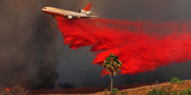 A DC-10 aircraft drops fire retardant on a wind driven wildfire in California.