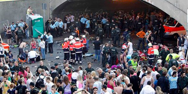 Collapsed people get first aid after a panic on this year's techno-music festival "Loveparade 2010" in Duisburg, Germany, on Saturday, July 24, 2010. German police say that 10 people were killed and 15 others injured when mass panic broke out in a tunnel at the Love Parade. (AP Photo/dapd/Hermann J. Knippertz)