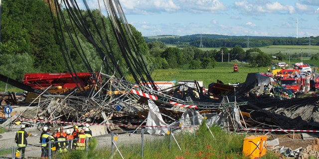 June 15, 2016: Firefighters stand near a collapsed scaffolding at a highway bridge near Werneck northern Bavaria, Germany.