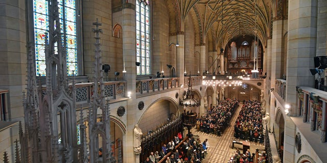 Visitors of the service sit in the All Saints' Church or Castle Church in Wittenberg, Germany, Tuesday Oct. 31, 2017. German leaders will mark the 500th anniversary of the day Martin Luther is said to have nailed his theses challenging the Catholic Church's practice of selling indulgences to a church door, a starting point of the Reformation. (Hendrik Schmidt/dpa via AP)