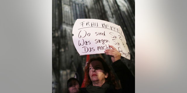 A woman protests against sexism outside the cathedral in Cologne, Germany, Tuesday Jan. 5, 2016. Poster reads " Mrs. Merkel. Where are you? What do you say? It's scary." (Associated Press)