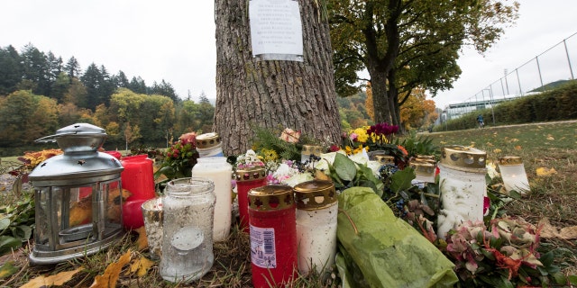 Oct. 21, 2016: Flowers and candles sit in front of a tree close to the Dreisam river in Freiburg, Germany, where the body of a student was found. A 17-year-old Afghan migrant, who entered Germany last year as an unaccompanied minor, was arrested Friday in connection with the killing.