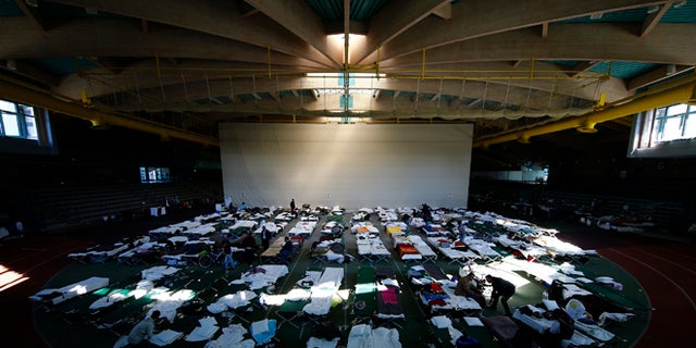 October 1, 2015: Migrants rest at a temporary shelter in a sports hall in Hanau, Germany.