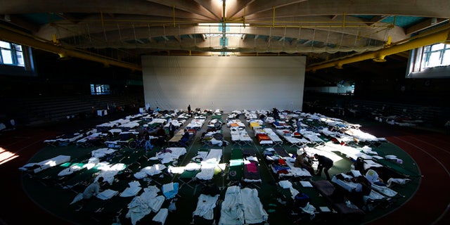 October 1, 2015: Migrants rest at a temporary shelter in a sports hall in Hanau, Germany.