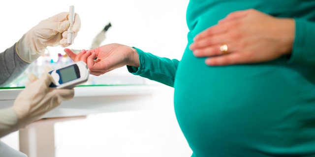 A pregnant woman gets her blood sugar/glucose checked.