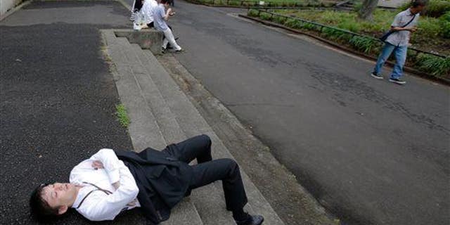 A man takes a nap as he takes advantage of a break of the rainy season at Hibiya Park in Tokyo, Tuesday, June 10, 2014. Is he "violating spatial norms"?