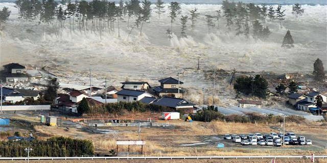 In this March 11, 2011 aerial photo, a tsunami hit Natori, Miyagi Prefecture, northeastern Japan. (Kyodo News via AP, File)