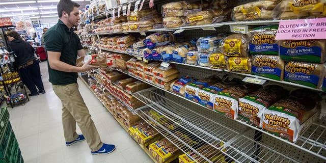 Bridgewater College junior communication major Jonah Barnhart, of Culpepper, Va., a floor stocker at Bridgewater Foods, stocks the bread aisle on Wednesday, Jan. 20, 2015, in Bridgewater, Va.