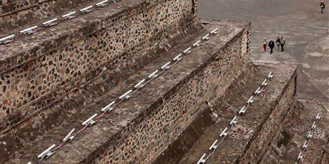 Tourists walk toward the Pyramid of the Moon in Teotihuacan, Mexico.