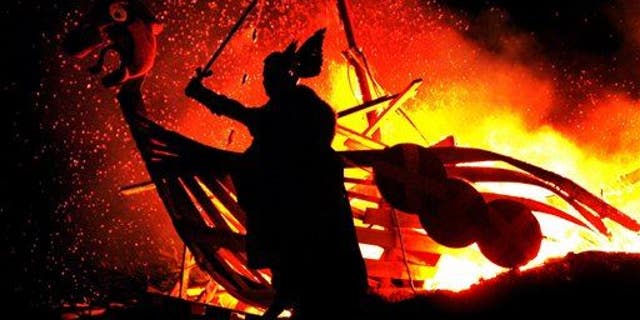 A reveler dressed as a Viking takes part in a 'Torchlight Procession' in Edinburgh.