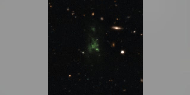 A giant green "space blob" - called the Lyman-alpha blob LAB-1 - is seen in this composite of two different images taken by the Very Large Telescope in Chile. The LAB-1 space blob is 300,000 light-years across,