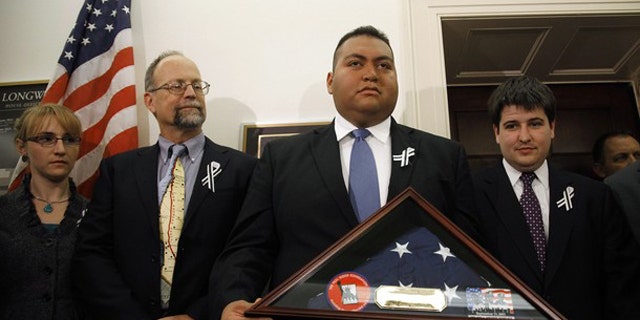 January 25: Daniel Hernandez, the intern credited with saving the life of U.S. Congresswoman Gabrielle Giffords after she was shot in Arizona, holds a U.S. flag presented to him by first responders from the September 11, 2001 attack on New York's World Trade Center