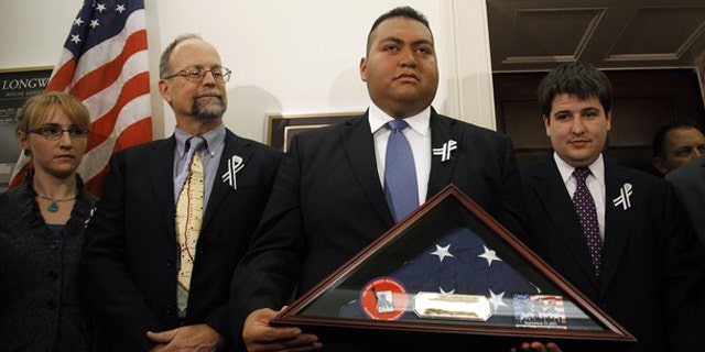 January 25: Daniel Hernandez, the intern credited with saving the life of U.S. Congresswoman Gabrielle Giffords after she was shot in Arizona, holds a U.S. flag presented to him by first responders from the September 11, 2001 attack on New York's World Trade Center