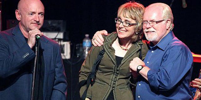 June 9, 2012: From left, Gabrielle Giffords' husband Mark Kelly, Giffords and congressional candidate Ron Barber gather during a get-out-the-vote rally at the Rialto Theater in downtown Tucson, Ariz.