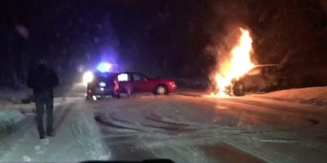 Ralph Gilles approaches the scene of an accident after using his Jeep to push a flaming SUV away from a car with passengers stuck inside.