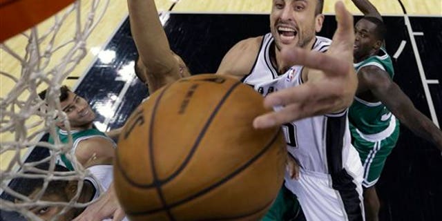 Manu Ginobili of Argentina reaches over Boston Celtics' Courtney Lee on Wednesday, Nov. 20, 2013, in San Antonio.