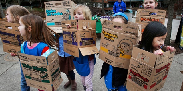 In a Feb. 18, 2013 file photo dressed in boxes emptied from earlier cookie sales, Girl Scouts from Troop 20337 in Eugene fan out on the University of Oregon campus near the Erb Memorial Union in Eugene, Ore., in search of customers for their cookies. Just a year after its 2012 centennial celebrations, the Girl Scouts of the USA's interconnected problems include declining membership and revenues, a dearth of volunteers, rifts between leadership and grass-roots members, a pension plan with a $347 million deficit, and an uproar over efforts by many local councils to sell venerable summer camps.