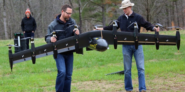 Engineers David North (L) and Bill Fredericks (R) carry the Greased Lightning before one of its flight tests. (NASA Langley/David C. Bowman)