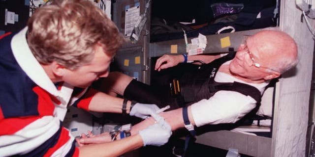 Astronaut John Glenn (right) gets bloodwork done in his bunk aboard space shuttle Discovery in 1998. About half of astronauts require sleep medication at some point during their flights, NASA said.