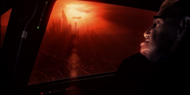 Astrophysicist Stephen Hawking views a CGI alien civilization on the exoplanet Gliese 832c in this still from the new documentary "Stephen Hawking's Favorite Places."