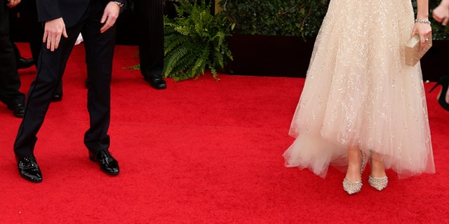 Actress Zooey Deschanel and actor Jesse Tyler Ferguson talk on the red carpet at the 71st annual Golden Globe Awards in Beverly Hills, California January 12, 2014. REUTERS/Danny Moloshok (UNITED STATES - Tags: Entertainment)(GOLDENGLOBES-ARRIVALS) - RTX17B5Z