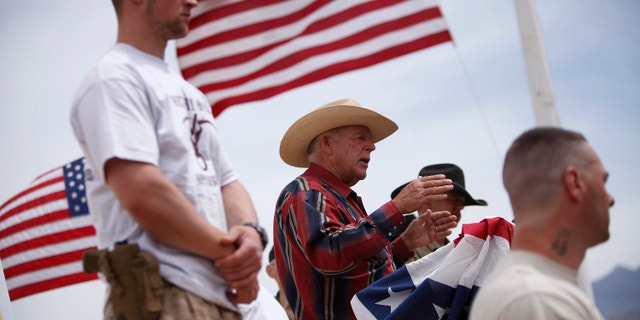 Rancher Cliven Bundy, flanked by armed supporters, speaks at a protest camp near Bunkerville, Nevada, on April 18, 2014.