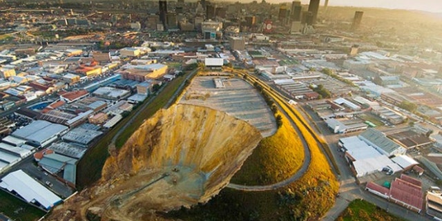 Johannesburg's landmark Top Star mine waste dump, shown here during the early stages of removal, once hosted a drive-in movie theater. Now it is gone, and the land reclaimed. (Courtesy: DRD Gold)