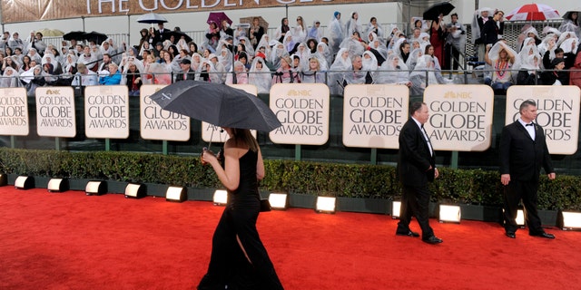 Jan. 17, 2010. A publicist walks down the red carpet as it rains before the 67th Annual Golden Globe Awards in Beverly Hills, Calif.
