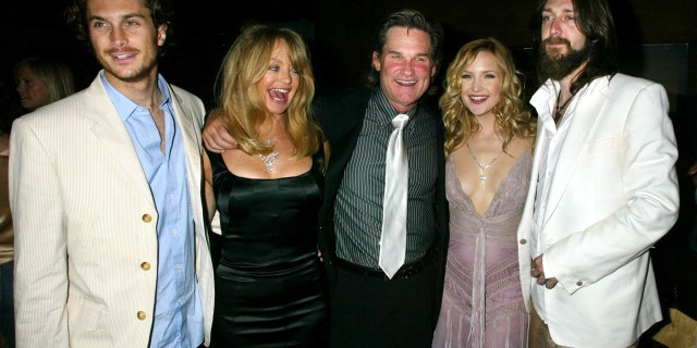 Actress Kate Hudson poses with her family at the party following the premiere of her new comedy film "Raising Helen" in Hollywood May 26, 2004. Shown (L-R) brother Oliver Hudson, Goldie Hawn, Hudson's mother,actor Kurt Russell,Hawn's companion,Kate Hudson and her husband, musician Chris Robinson.Hudson portrays a modeling agency assistant who suddenly is faced with the death of her sister and raising her sister's children. The film opens May 28 in the United States. REUTERS/Fred Prouser FSP/JV - RTRKFRK