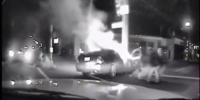 A Good Samaritan and a Louisville police officer saved two people from a burning car.