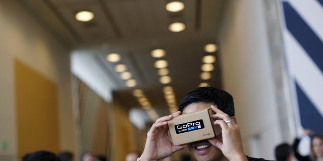 File photo - A conference attendee looks through "Cardboard," a viewer that enables the user to view content from a smart phone in 3D, during the Google I/O developers conference in San Francisco, Calif. May 28, 2015. (REUTERS/Robert Galbraith)