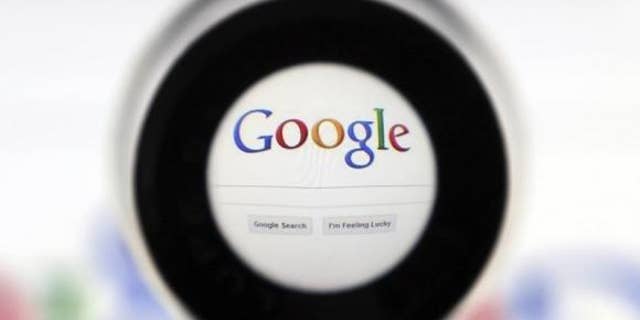 May 30, 2014: A file photo of a Google search page is seen through a magnifying glass in this photo illustration taken in Brussels.