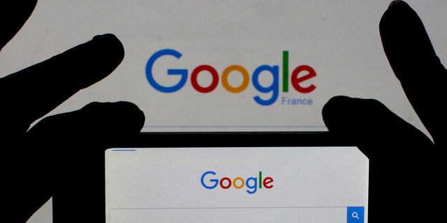A woman holds her smart phone which displays the Google home page, in this picture illustration taken Feb. 24, 2016. (REUTERS/Eric Gaillard/Illustration)